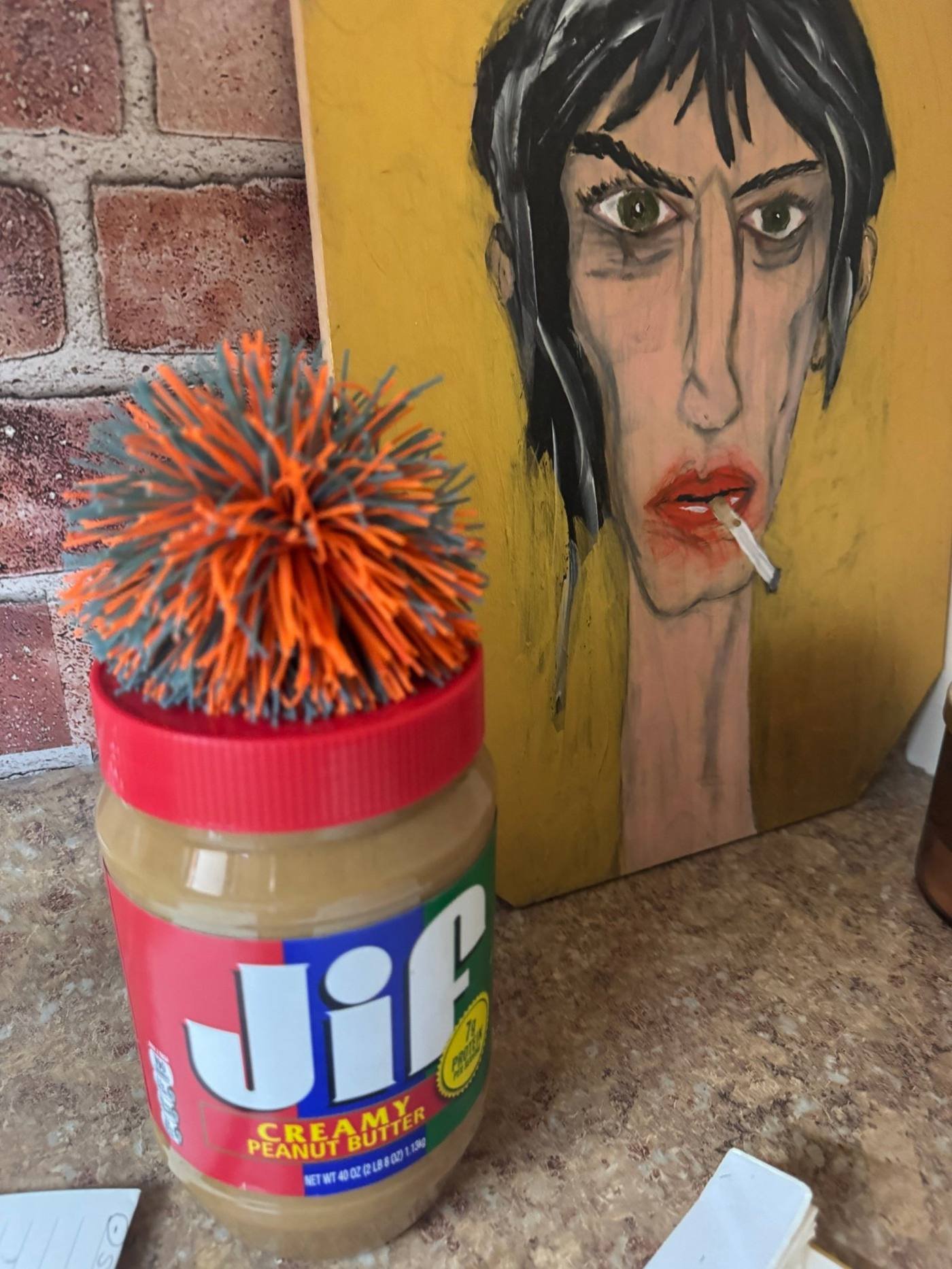 One of J. Mike Oliver's paintings propped against a brick wall